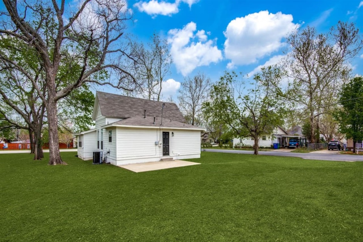 Expansive backyard with lush green lawn and parking for up to 4 vehicles. Perfect for wedding parties and larger groups. Modern farmhouse Airbnb in Aubrey TX near Lake Ray Roberts and top Denton County wedding venues.