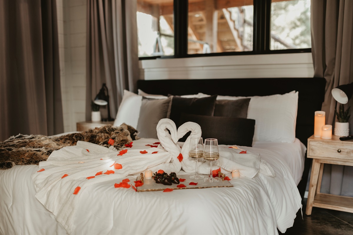 An optional romantic setup includes swan towels, rose petals, candles, and a tray of treats. This dreamy bedroom is designed for honeymoons, anniversaries, or simply time together. This romance package is available for an additional fee.