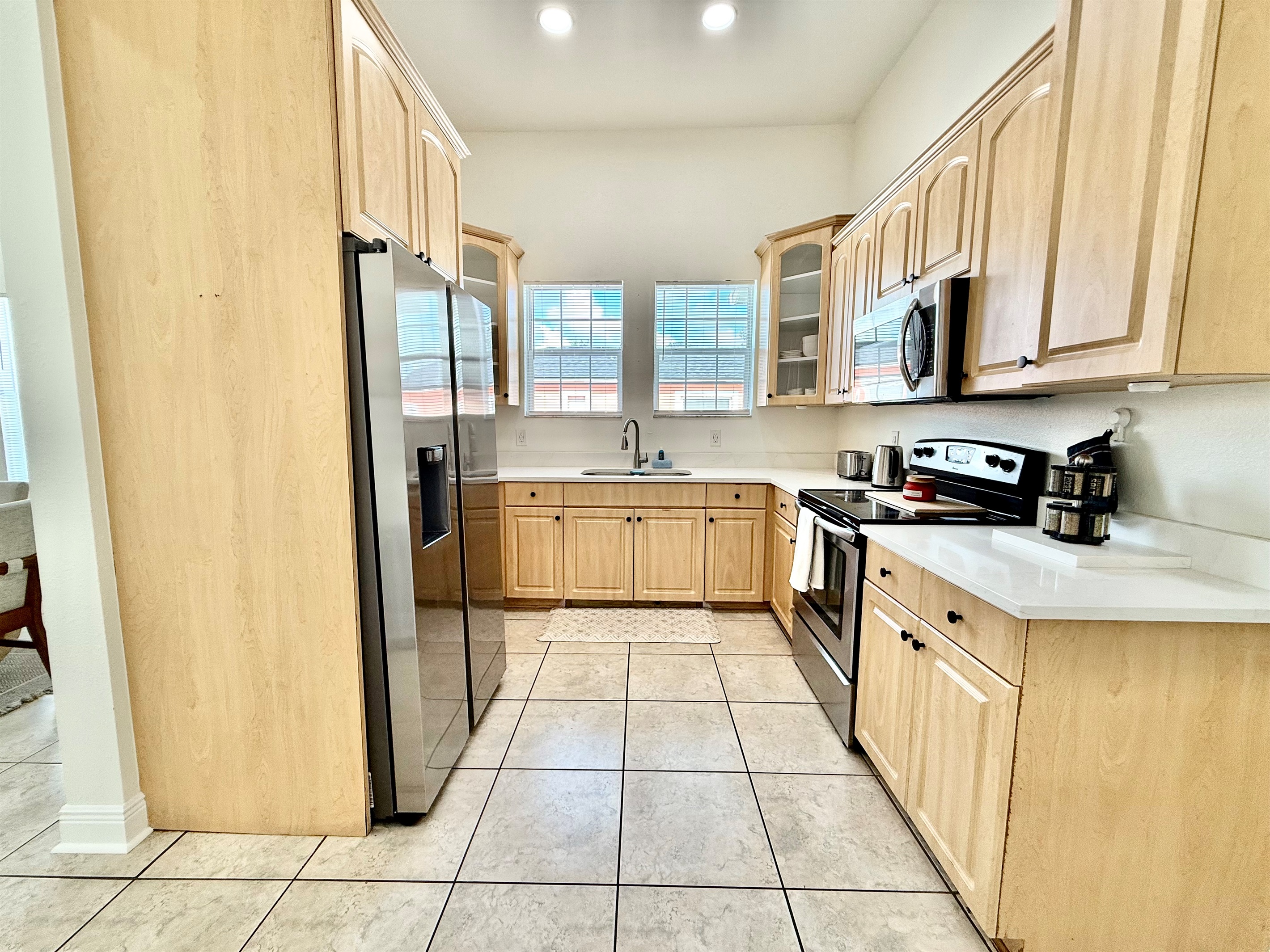 Bright and open kitchen featuring sleek appliances, ample counter space, and a warm, natural wood aesthetic.