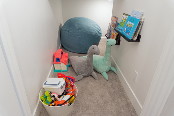 Understair play area includes monster themed book, toys and bean bag chairs