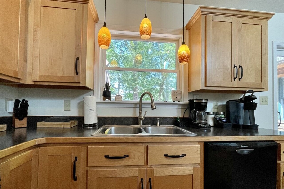 Kitchen sink with a window view of the back deck and beyond