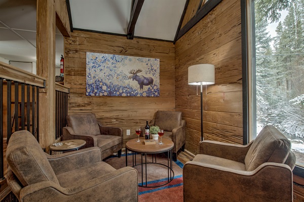 Unwind in your cozy lounge—gather around with a glass of wine, surrounded by warm wood tones and peaceful forest views made just for you and yours.