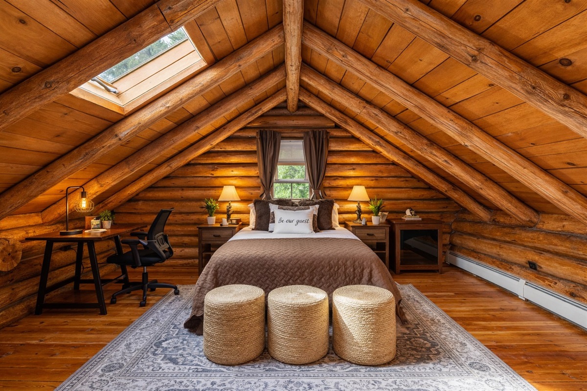 Sleep under the stars — or at least under the beams! This cozy upstairs retreat features a queen bed, charming skylight, and custom log craftsmanship that makes this room truly one-of-a-kind.