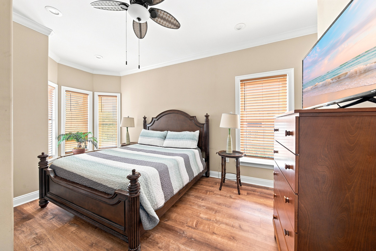 Guest bedroom with a ceiling fan and hardwood floors