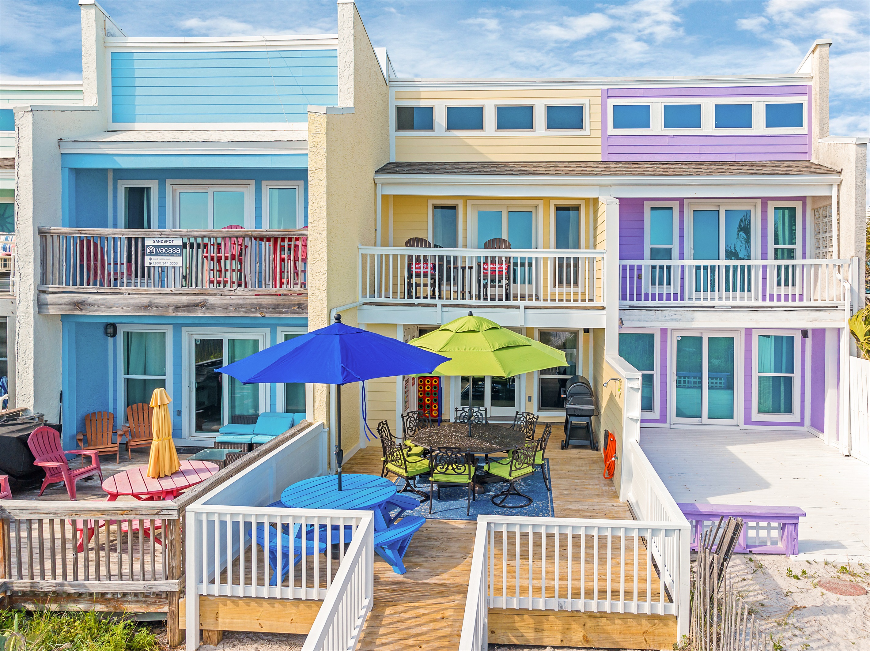 Enjoy the beach life in this colorful townhouse with a spacious deck perfect for outdoor dining and relaxation.