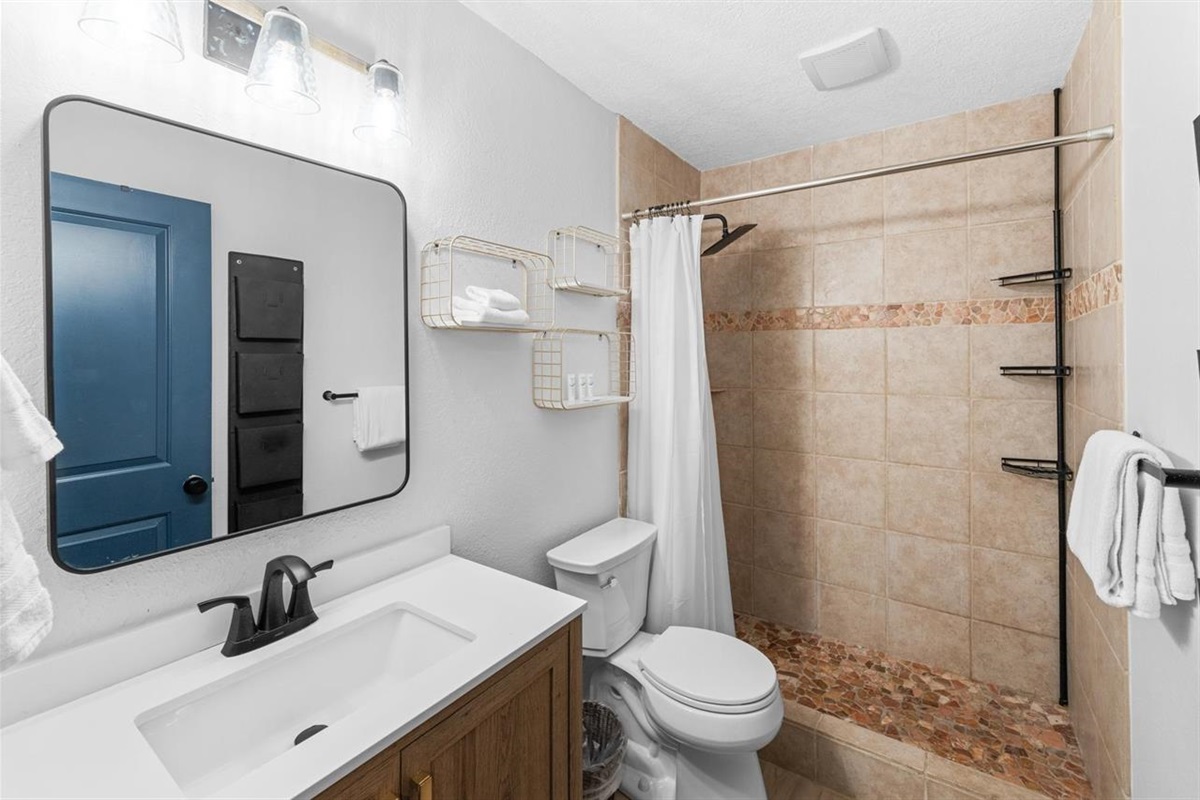Spa-style bathroom with tile and stone shower