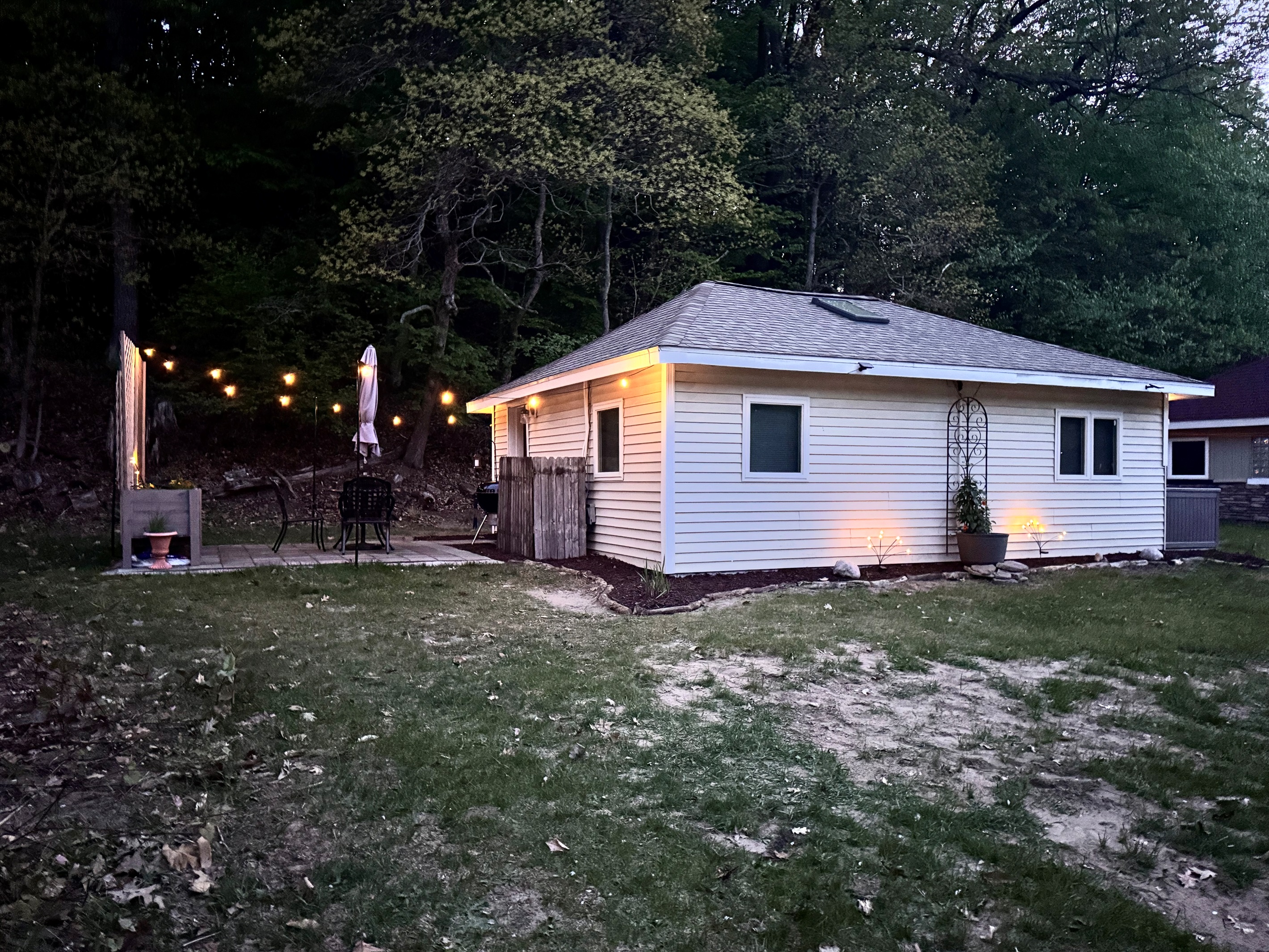 Duet Cottage - Dedicated door takes you to the back patio with a bistro set, umbrella, solo stove, charcoal grill and romantic string lights to enhance your stay.