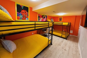 A bright and playful bunk room perfect for groups or family stays. With cozy beds and bold artwork, it’s a space designed for fun and relaxation.