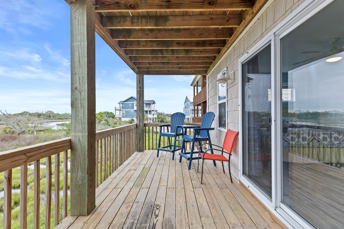 Covered balcony with high-top seating overlooking the peaceful marsh