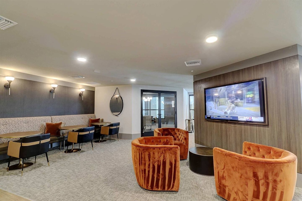 - Enjoy a comfortable lounge area with cozy chairs and large flat-screen TV   - Perfect for watching your favorite shows, meetings, or casual hangouts   - Modern lighting, soft seating, and warm tones set the relaxing mood