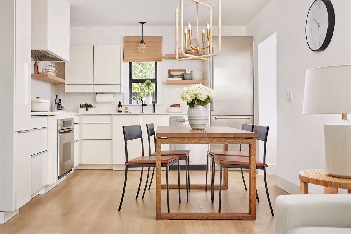 The chef’s kitchen features an inviting eat-in dining area and overlooks the illuminated bocce ball court. It’s equipped with marble counters, a Sub-Zero refrigerator with built-in ice maker, a Dacor oven and cooktop, and a custom plaster range hood.