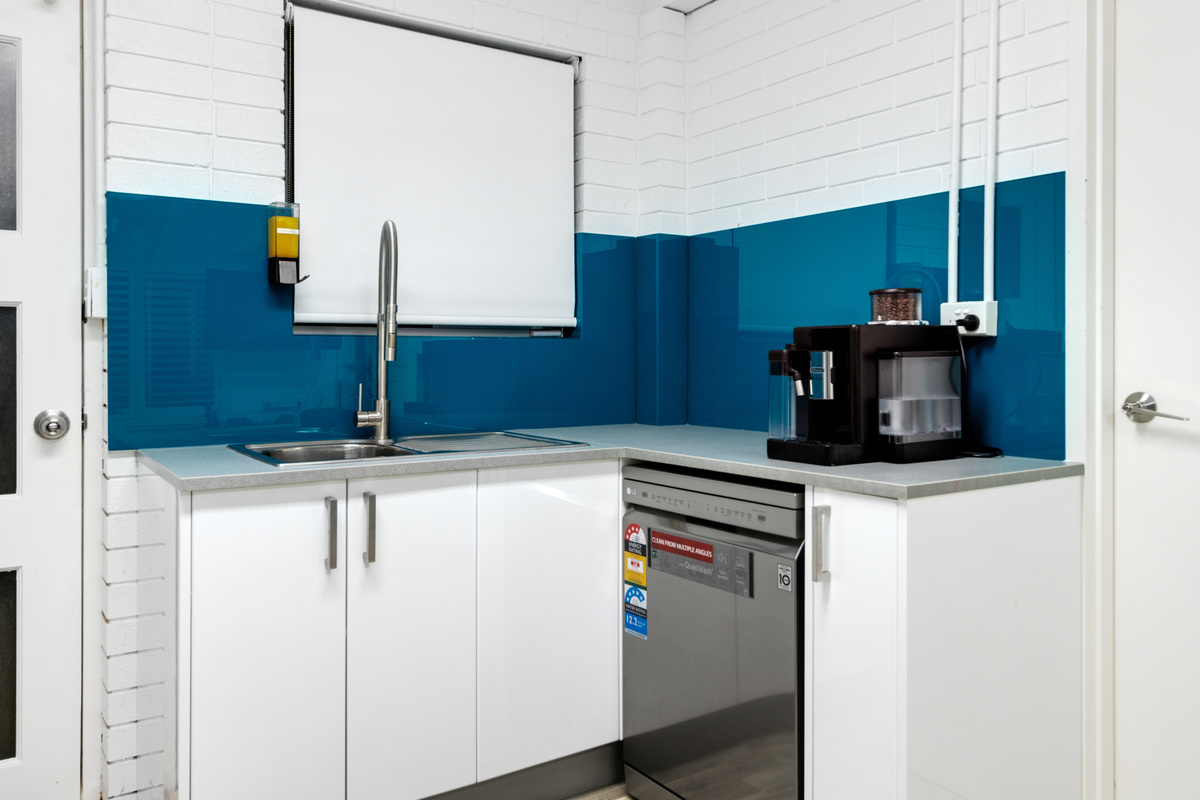 This downstairs kitchen angle at Skye’s Beach House Malua Bay shows the lower-level meal space in the Batemans Bay region.