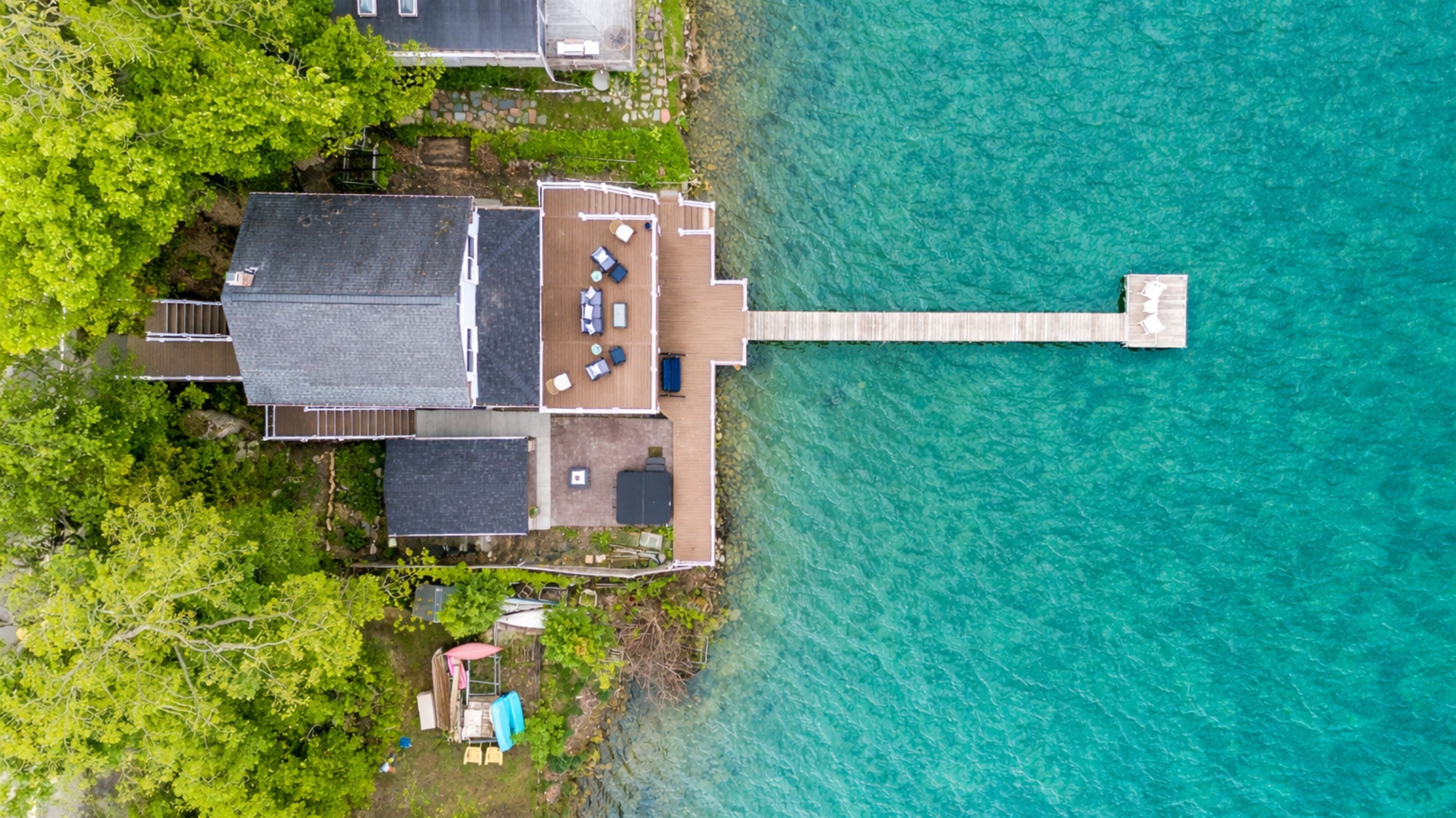 Aerial shot showcasing expansive lakefront entertaining space, hot tub, and private dock for the ultimate getaway 🎯🌊🍹