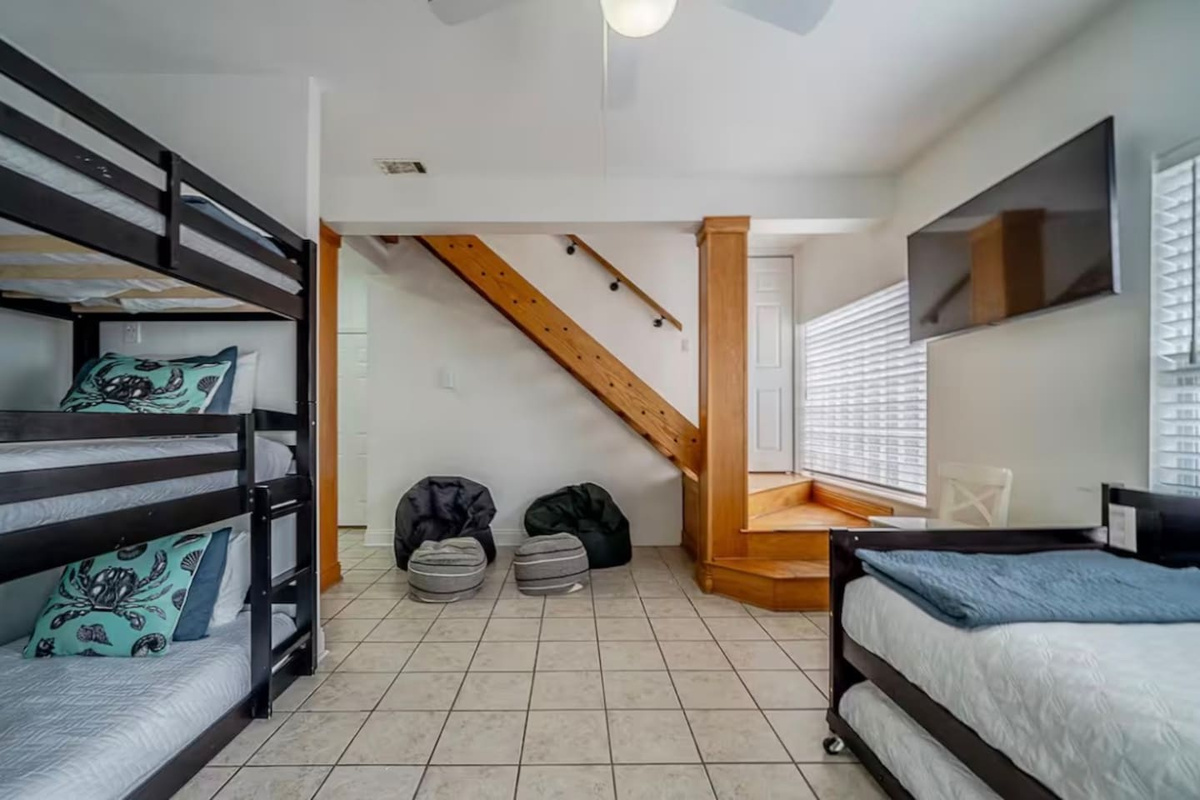 Spacious bunk room complete with multiple beds, flat-screen TV, and flexible sleeping arrangements for groups