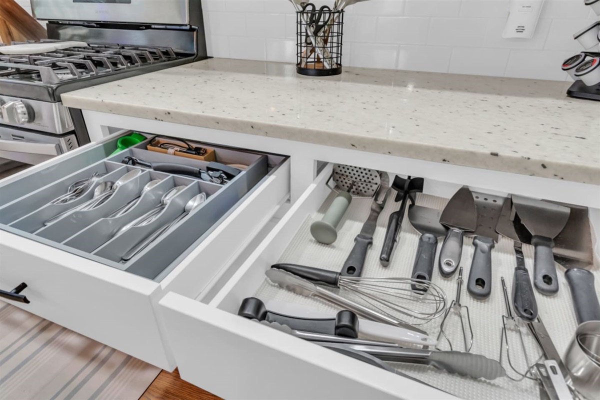 Kitchen drawers fully stocked with utensils for home cooking.