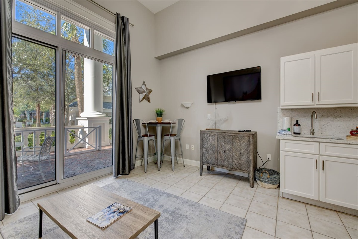 Across from the couch is a mounted flat screen TV, also visible from the bed.