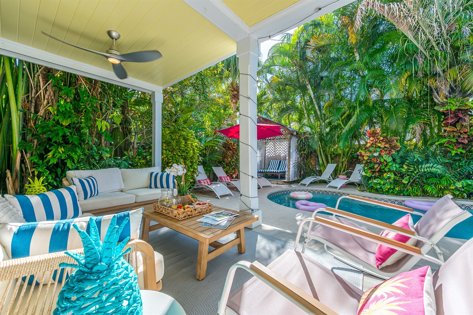 Step into your private tropical oasis featuring a heated pool, sun loungers, an outdoor shower, and a romantic string-lit cabana. Enjoy relaxing or entertaining under the covered patio with comfortable seating and dining, and magnificent pool views.