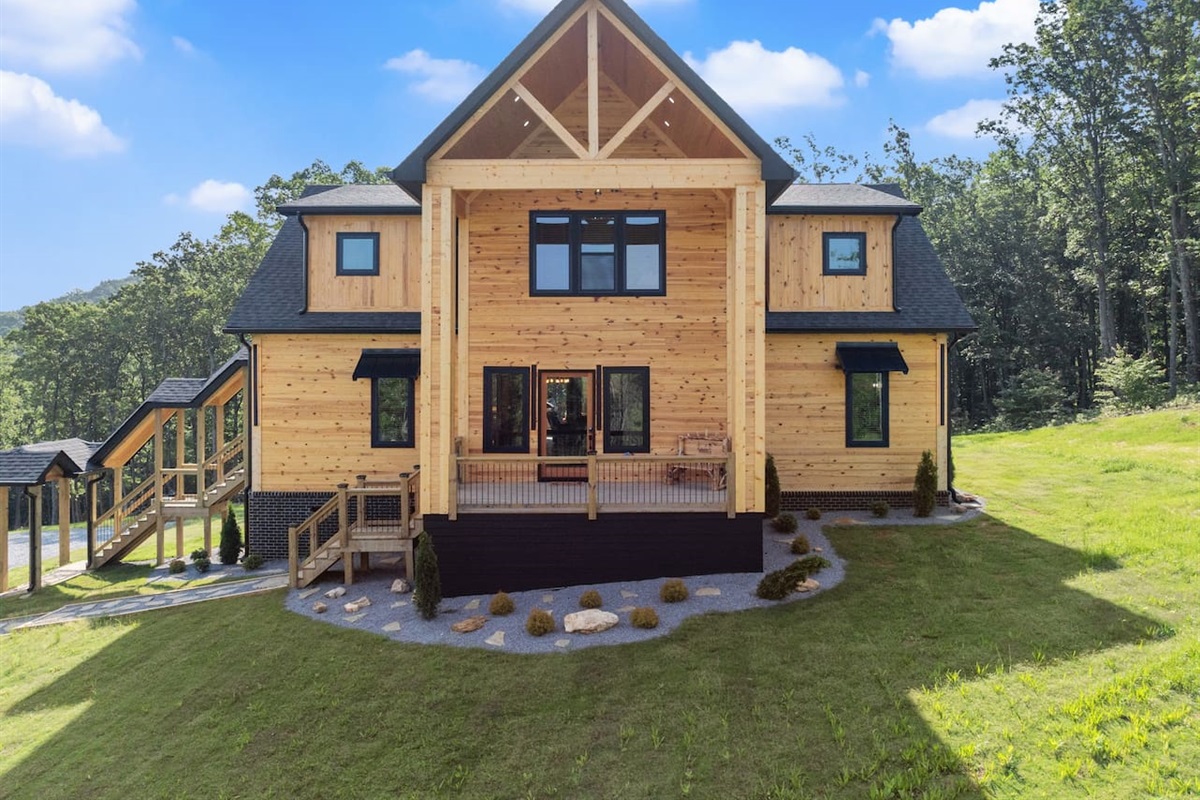 This front-facing shot captures the cabin’s dramatic A-frame design and inviting covered porch area.