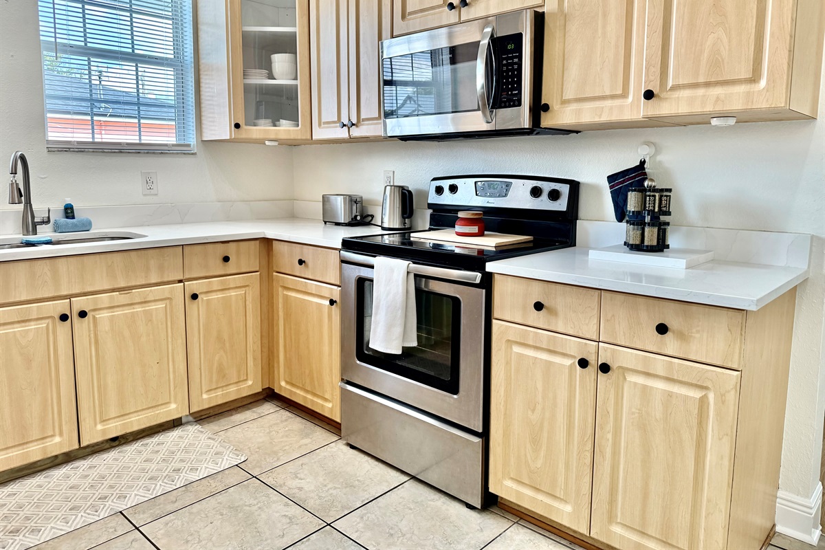 Natural wood cabinetry meets clean white countertops in this charming kitchen designed for both form and function.