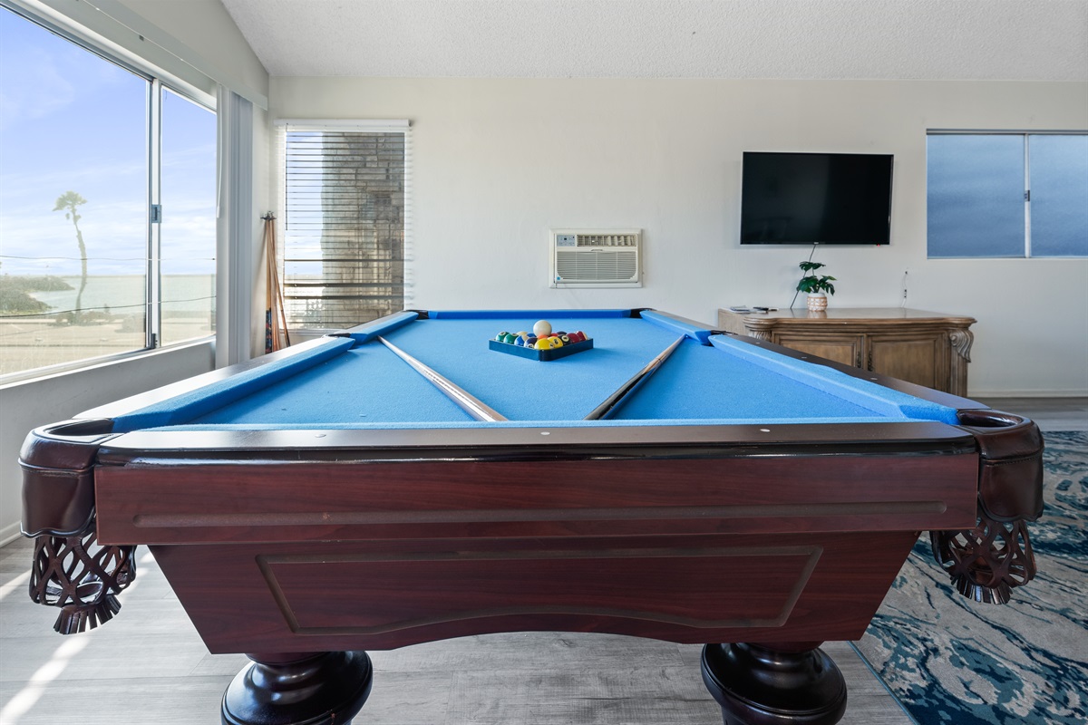 Full-size pool table in the main living area with 58 in smart tv