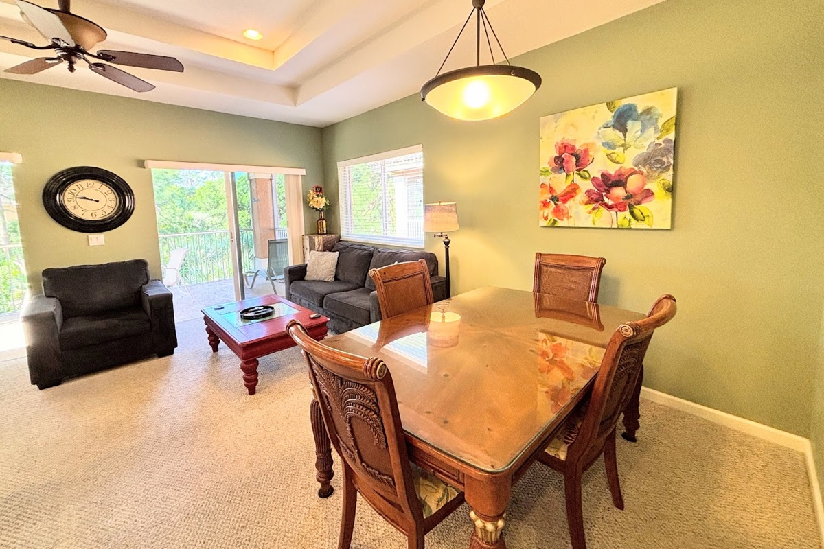 Spacious dining and living area with comfortable seating, large windows, and a warm, inviting layout.