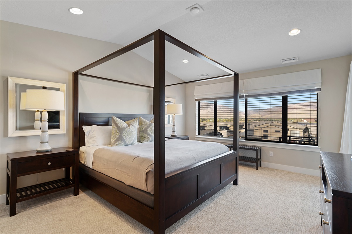 Elegant primary bedroom with large windows and mountain views.