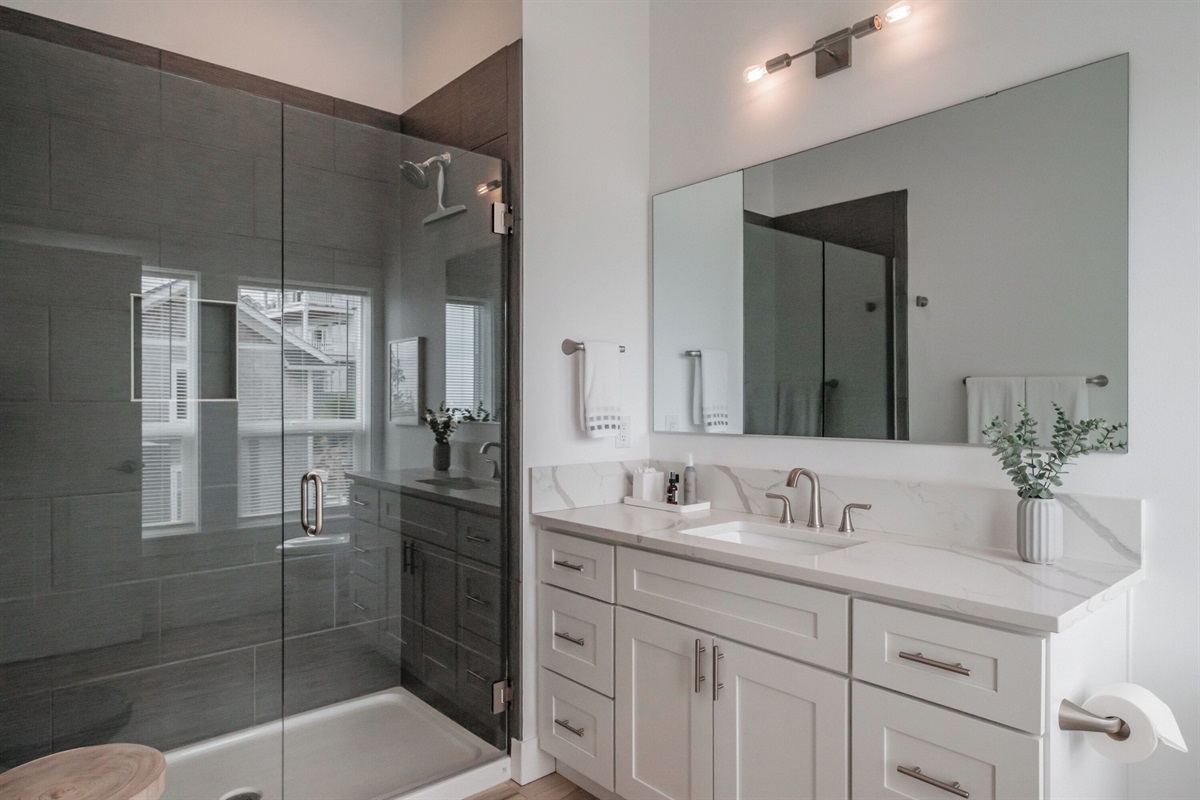 A spa-inspired master bathroom with a walk-in shower, and modern finishes for an elevated stay.