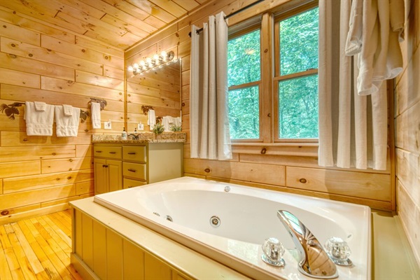 Primary bathroom with granite countertops, jacuzzi tub and shower