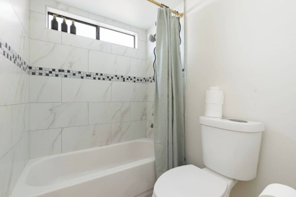 Clean and bright bathroom with marble tile, soaking tub, and skylights—spa-quality spaces designed for comfort and relaxation.