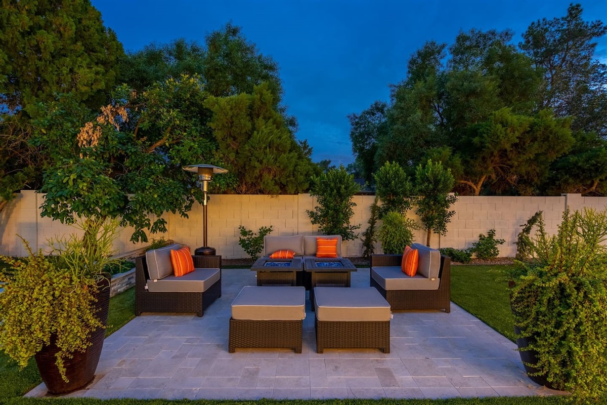 Experience unparalleled comfort on our outdoor sofa lounge, featuring soft throw pillows and a cozy fireplace. This serene setting offers a tranquil view of the pool and surrounding trees, perfect for unwinding after a long day.