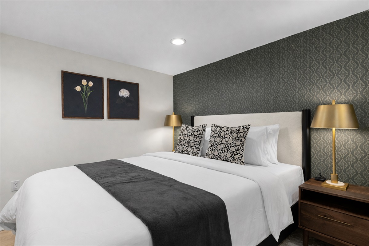Calm, inviting bedroom with a comfortable king bed, crisp linens, and warm bedside lighting—perfect for unwinding and enjoying a peaceful night’s sleep.