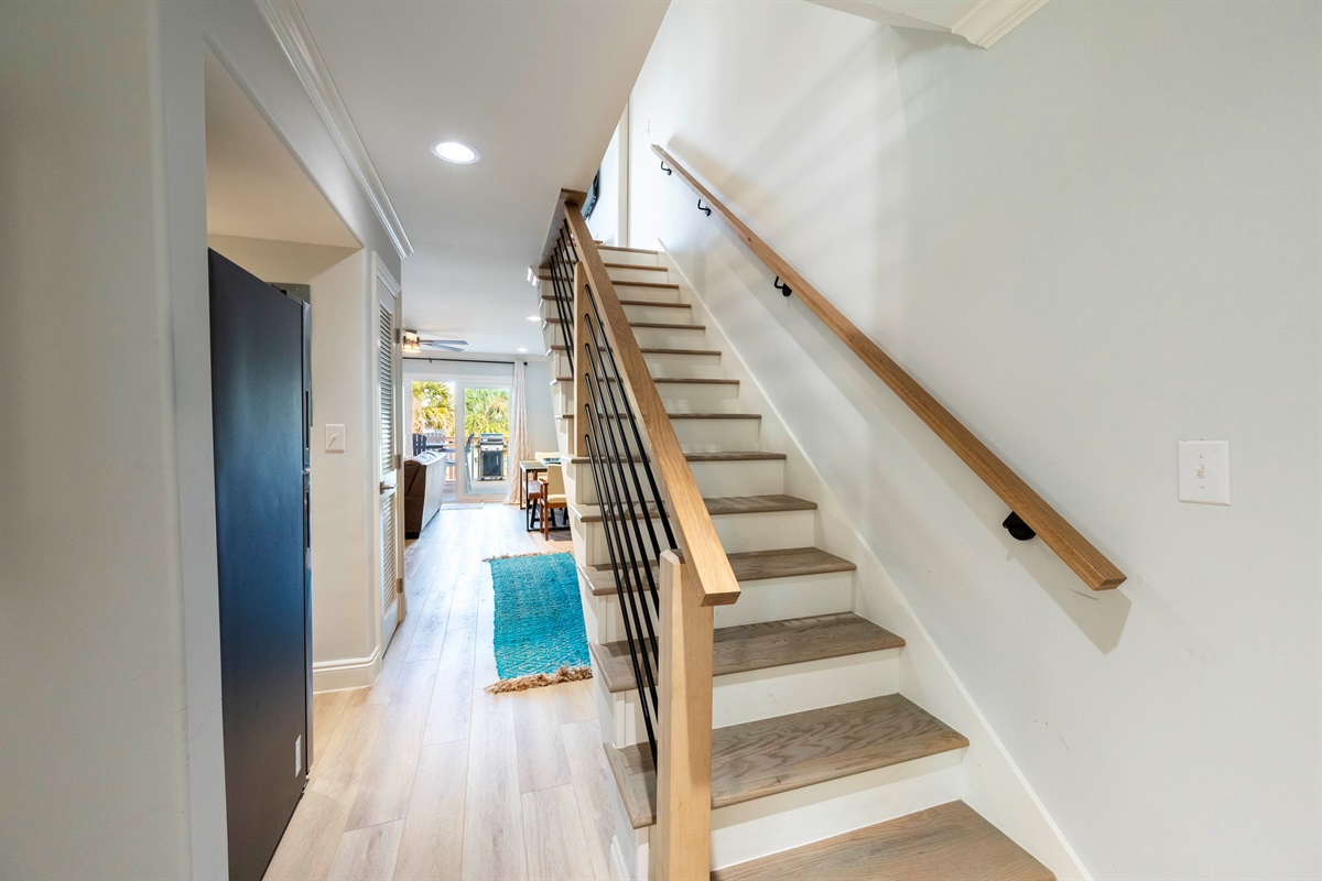  Elegant hallway with wooden stairs, cozy dining area, and natural light glow.