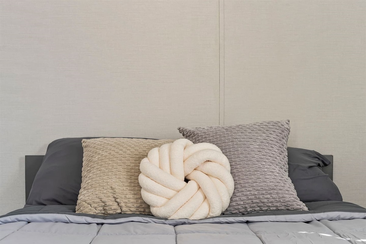 Close-up of the bed setup showcasing plush textures and thoughtfully styled decorative pillows.