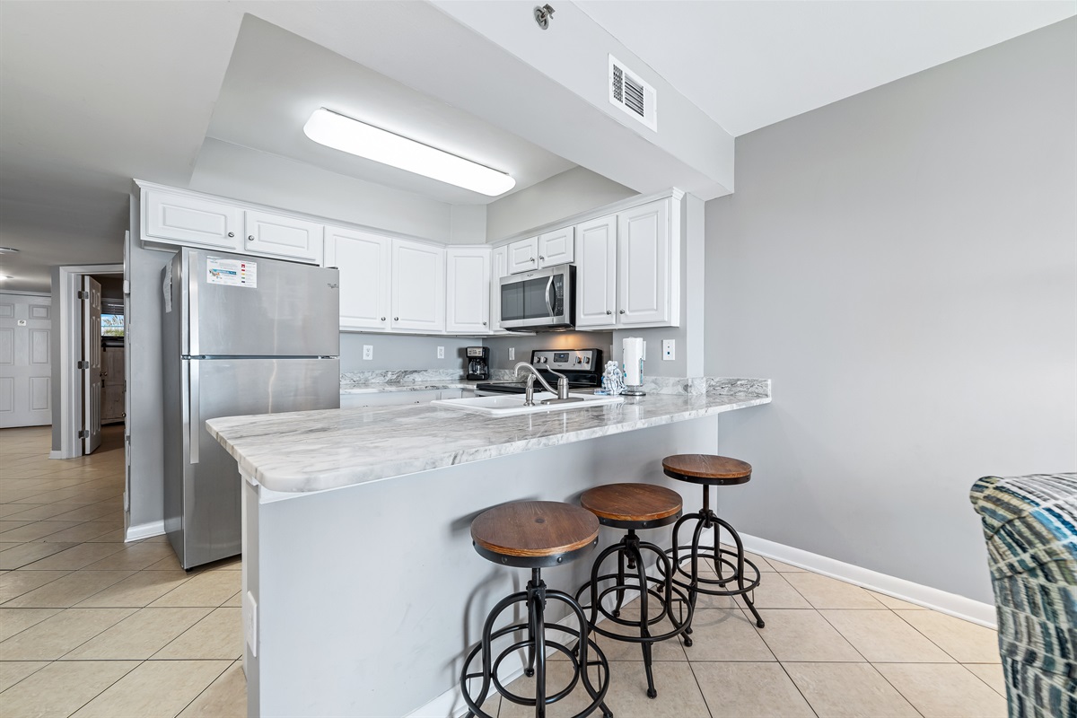 Flexible dining options for every occasion. Enjoy a formal meal at the dining table or a casual snack at the breakfast bar, seamlessly connected to the fully equipped kitchen.