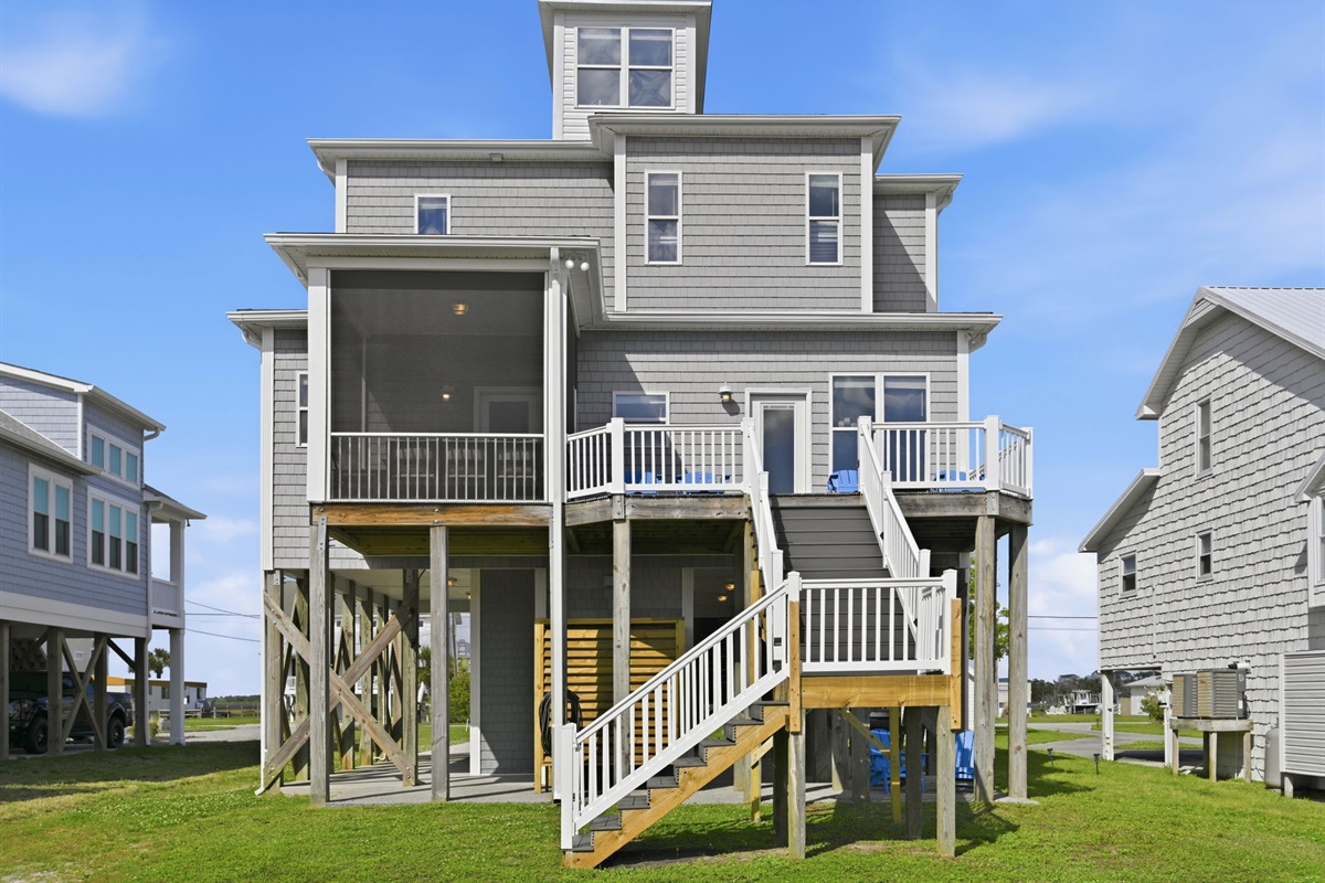 Rear exterior featuring multi-level decks, screened lounge area, and easy access to the dock and canal