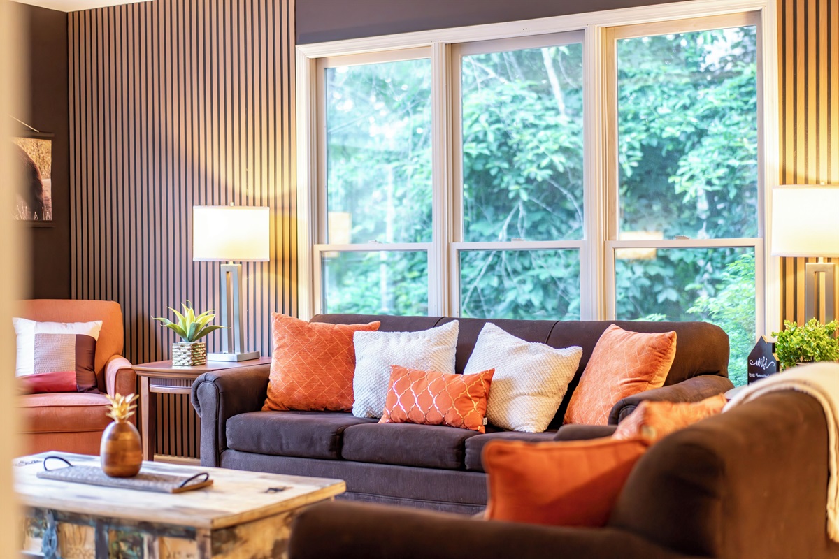 Living room with large TV, electric fireplace, and ample seating
