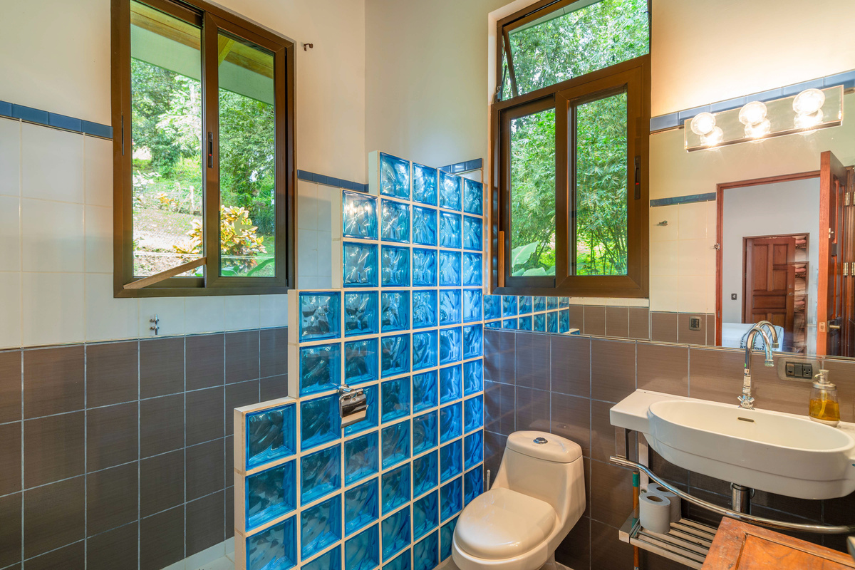 Private ensuite bathroom with blue glass tile shower
