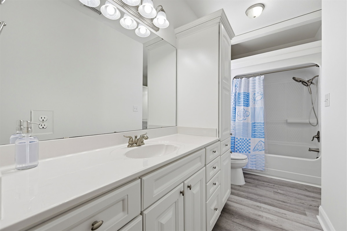 Spacious full bathroom with oversized vanity and tub/shower combo for easy group stays