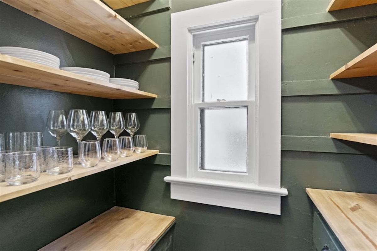 Bright full kitchen featuring neatly organized storage for plates and cups, large windows allowing natural light, and a clean, functional design—perfectly blending practicality and modern aesthetics for everyday comfort