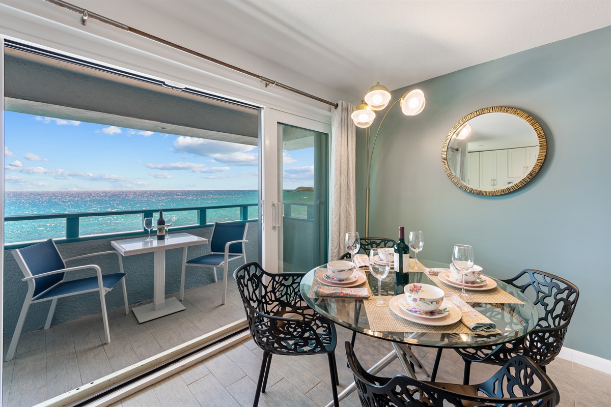 Indoor dining area leads out to the balcony with outdoor dining area for two