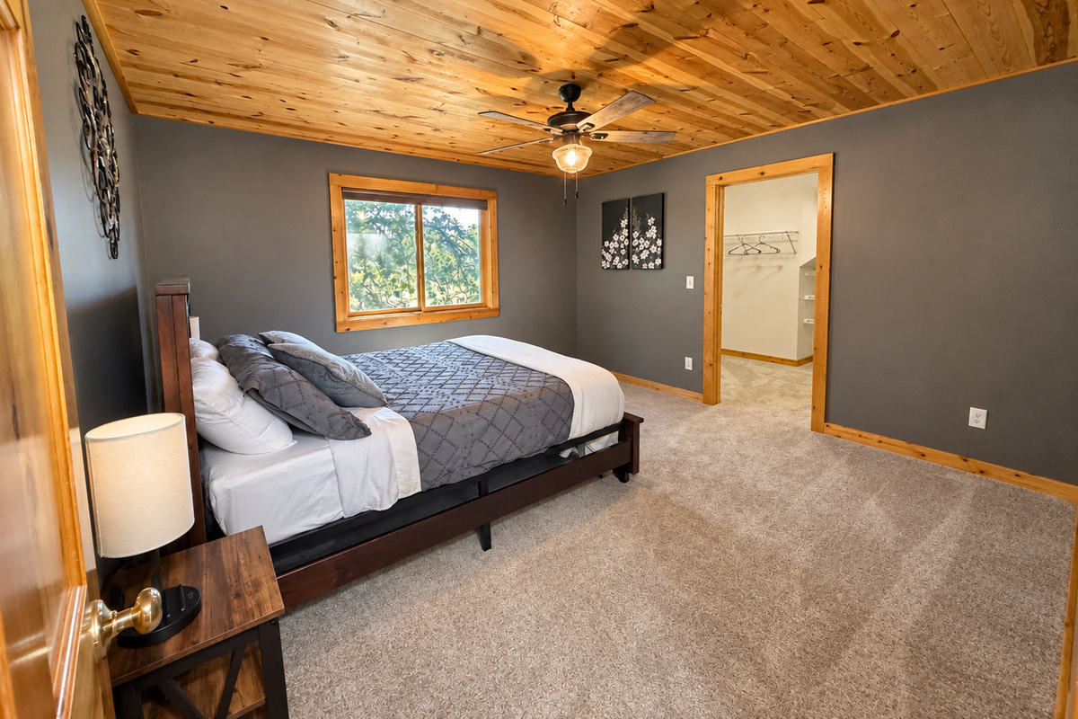 Warm wood ceilings and rustic finishes give this private bedroom a comfortable Northwoods feel. This spacious bedroom has a large walk in closet and room to spread out.