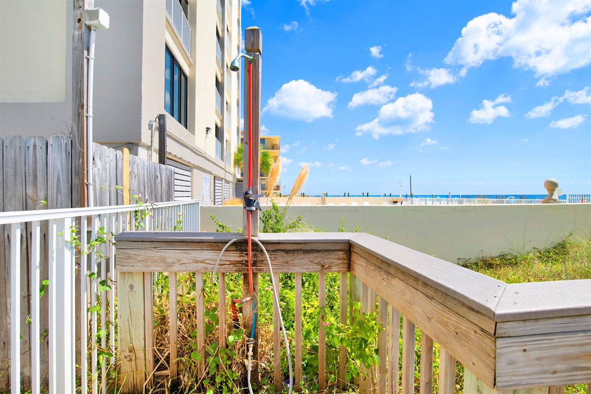 Shower by outdoor pool on beach boardwalk