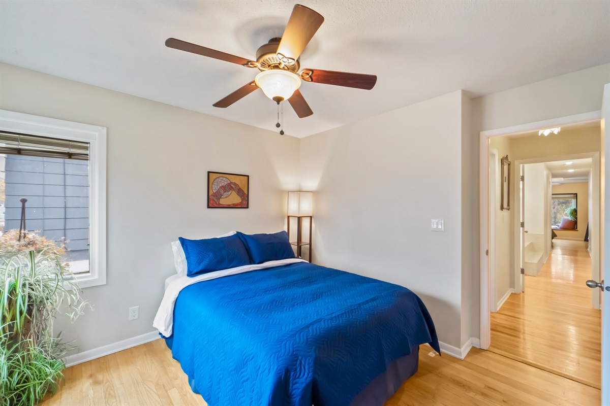 The second bedroom has a queen sized bed, dresser, large mirror, soft bedside light with shelves and a very happy spider plant.