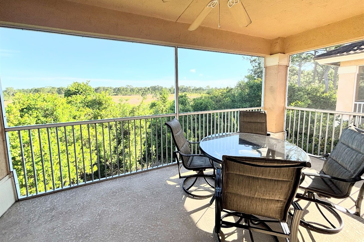 Spacious screened balcony offering plenty of room to relax, dine, and enjoy the outdoor views.