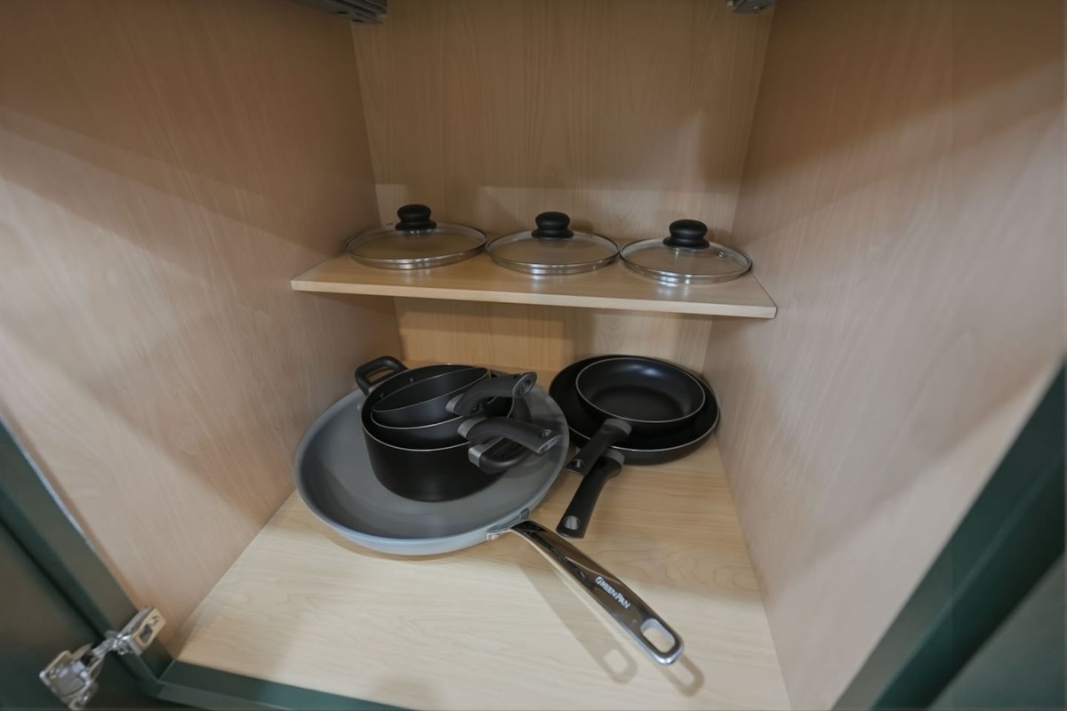 Cookware cabinet featuring pots, pans, and lids so you’ll have everything you need for cooking during your stay.
