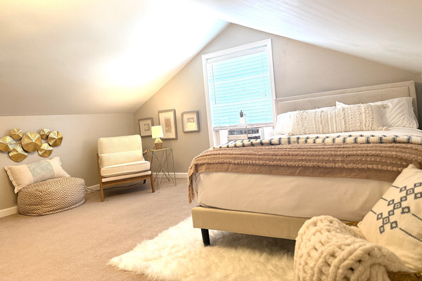 Bright upstairs bedroom with a double bed and historic loft-style character.
