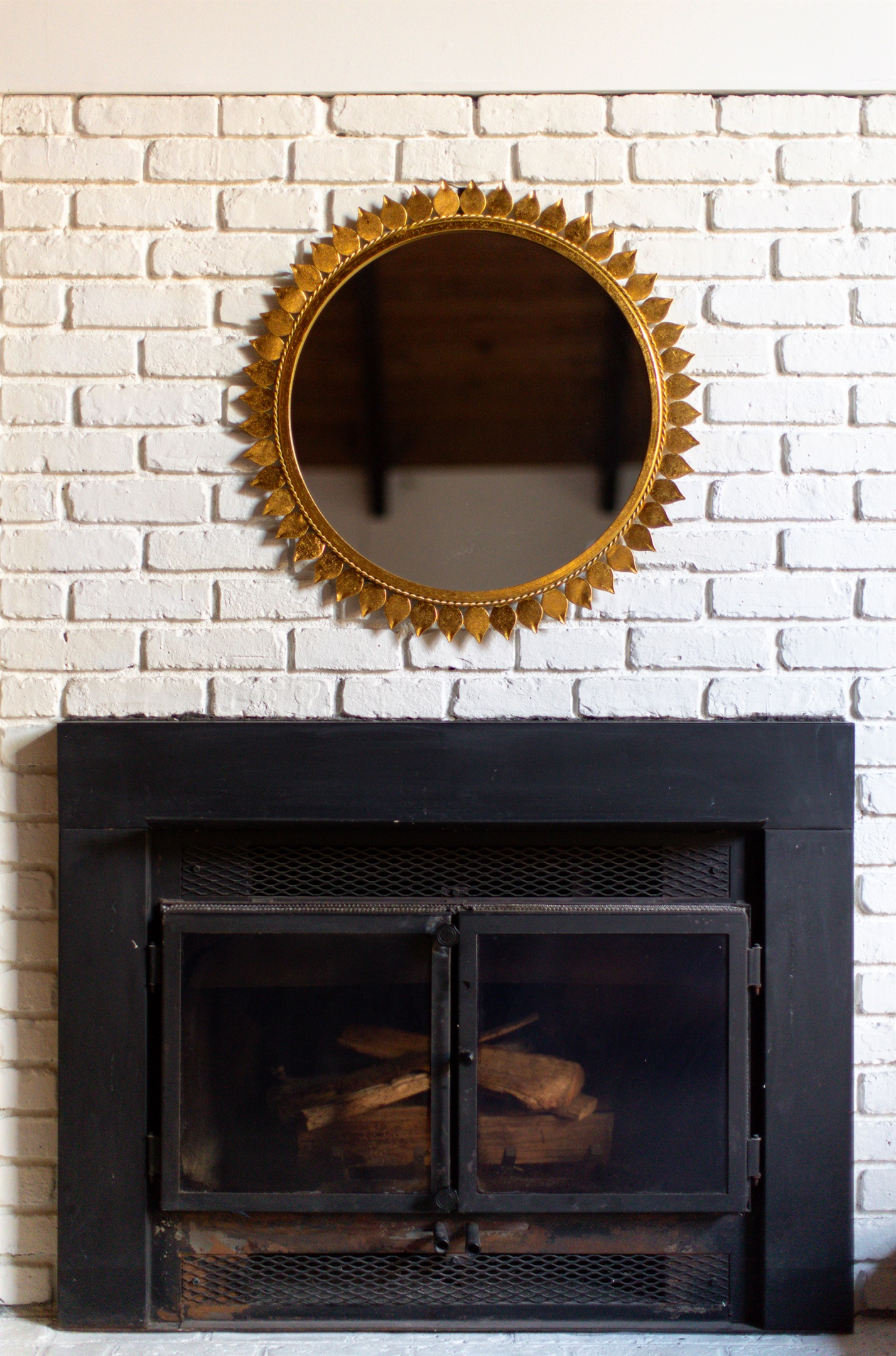 Indoor Fireplace: Stunning sunburst mirror complements the rustic fireplace, perfect for gatherings!