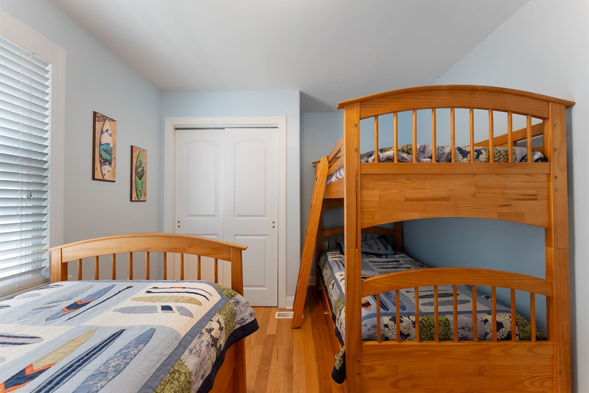 Bedroom features bunk beds and a single bed with a large closet for storage. 