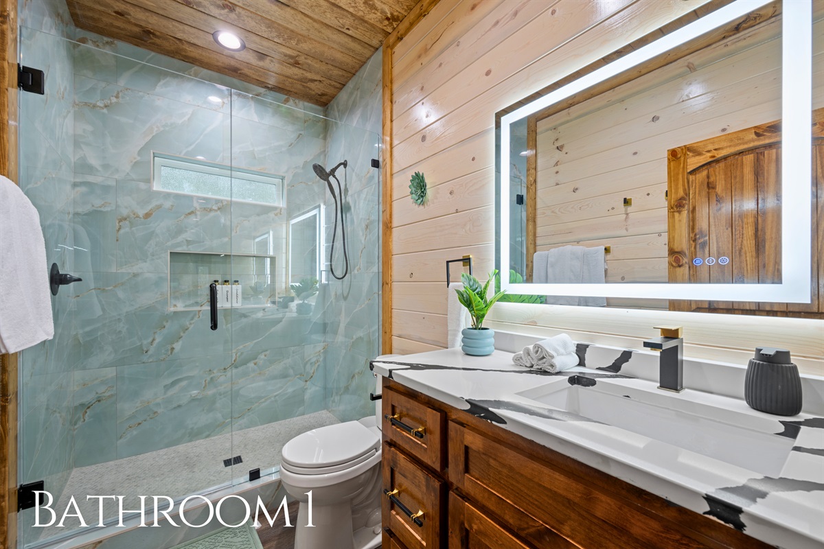 The spacious bathroom features a double vanity with plenty of counter space, making it easy for multiple guests to get ready while still enjoying the warm wood finishes throughout.