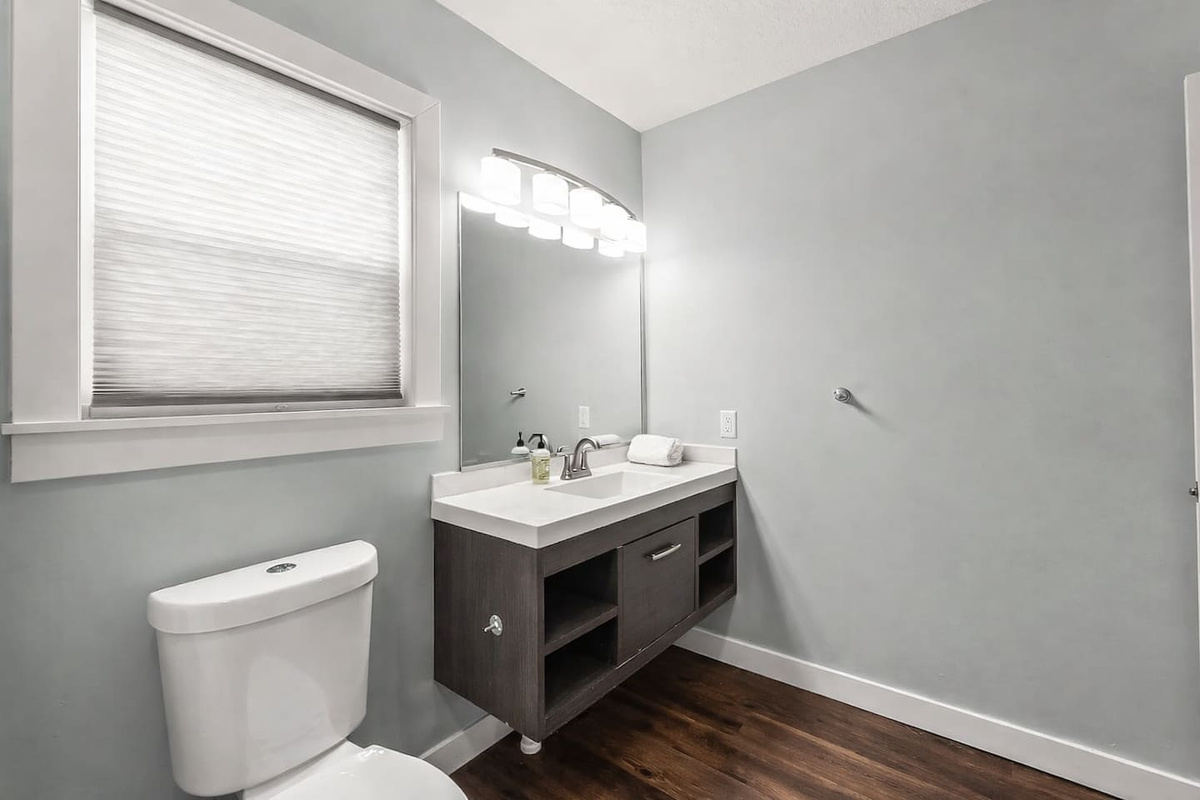 Clean vanity area with large mirror, contemporary lighting, and plenty of counter space for daily routines.